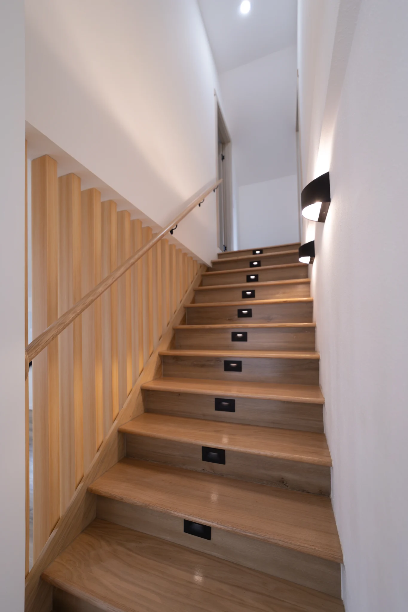 Floor Lit Stairs Made of Brown Wood & Wooden Slats Next To It