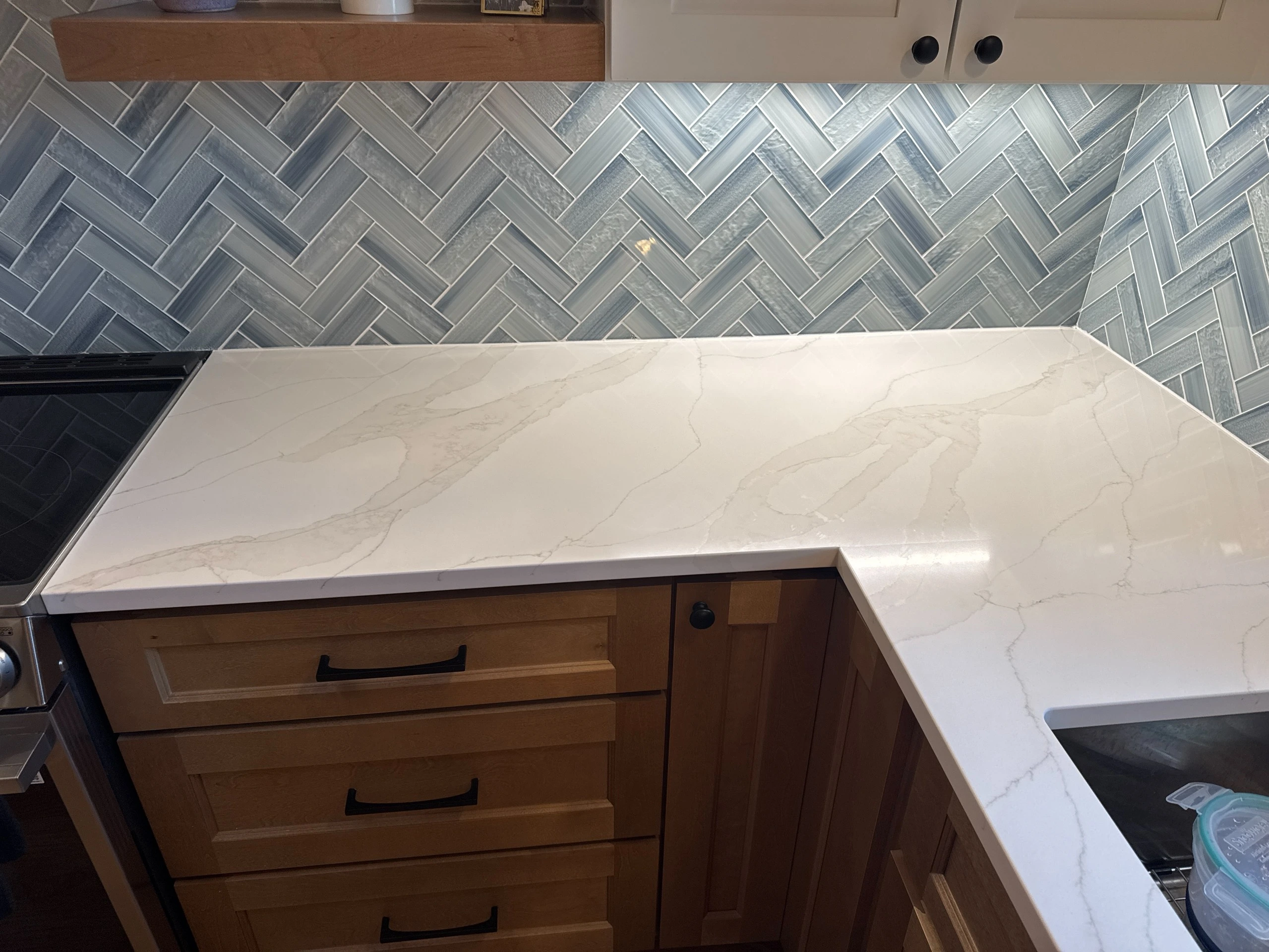 Newly Remodeled Kitchen With New Modern White Countertop and Brown Cabinetry