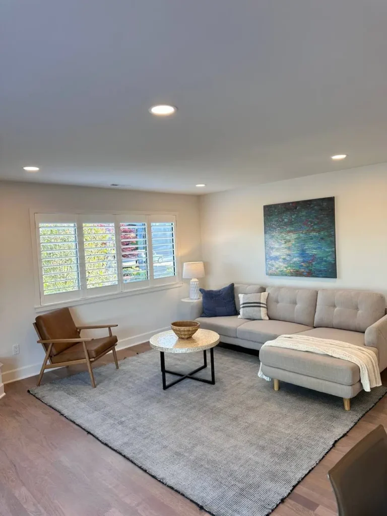 Main Living Room of Newly Remodeled Home With L Sofa And Modern Brown Chair Next To It