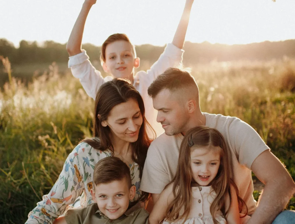 Happy Family Sitting In Open Prairie