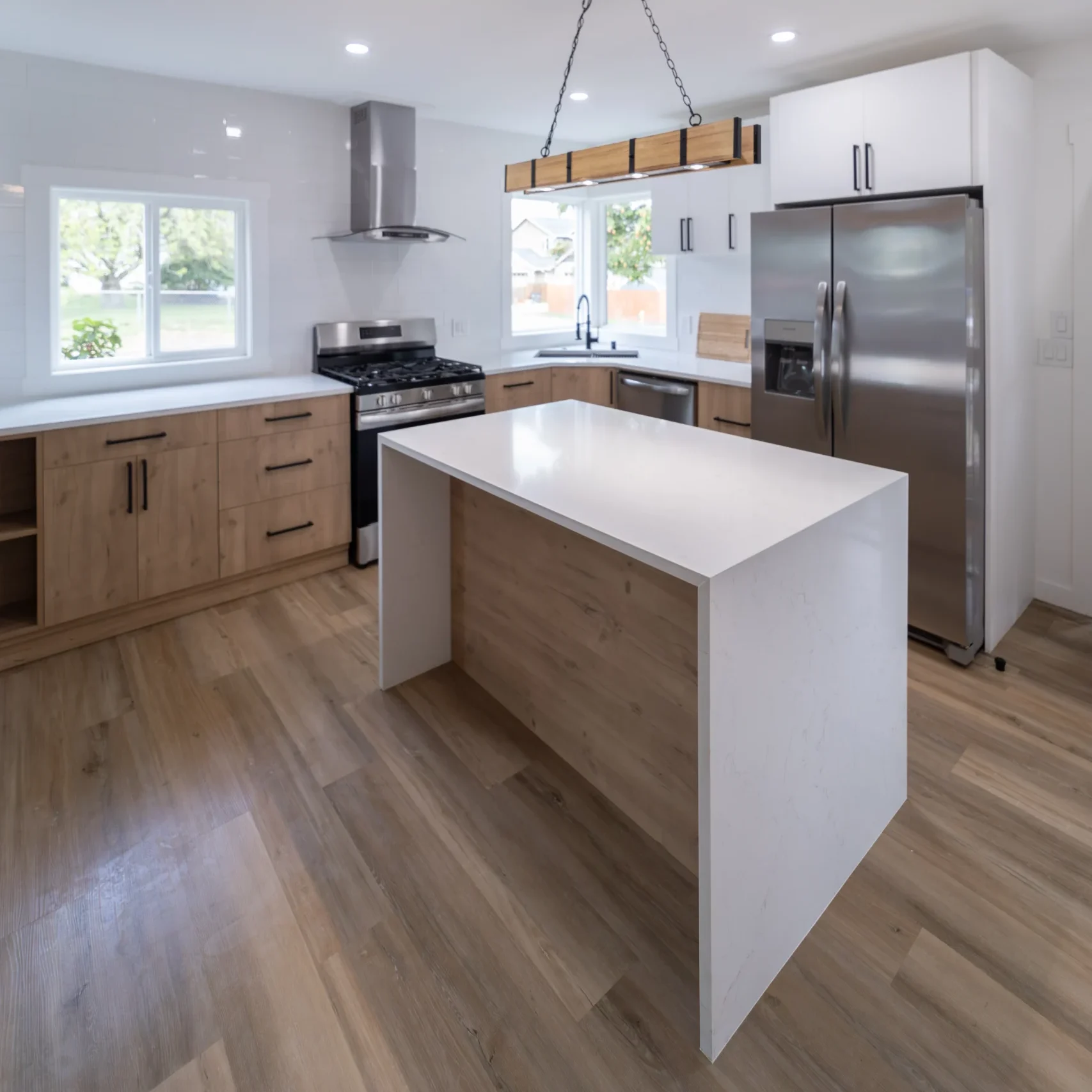 Recently Remodeled Kitchen With Waterfall Countertops Over Fixed Island & Wood Grain Cabinets