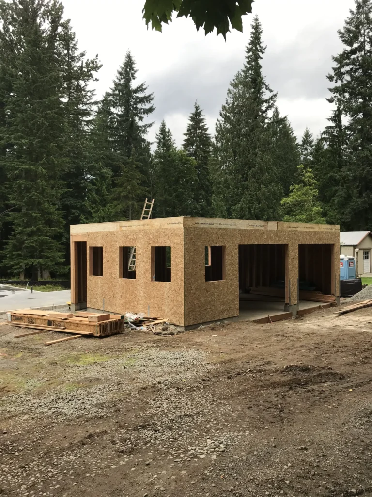 Custom Home Build In Progress With Garage Framed With Plywood & Foundation Laid